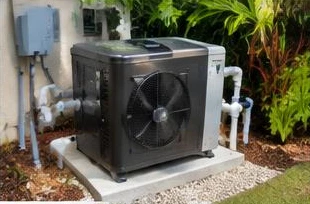 Heat pump pool heater hidden in a fenced side yard between a stucco wall and wooden fence