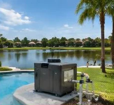 Heat pump pool heater hidden in a fenced side yard between a stucco wall and wooden fence