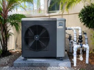 Heat pump pool heater hidden in a fenced side yard between a stucco wall and wooden fence