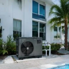 Heat pump pool heater hidden in a fenced side yard between a stucco wall and wooden fence