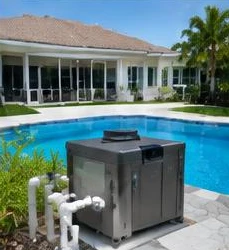 Heat pump pool heater hidden in a fenced side yard between a stucco wall and wooden fence