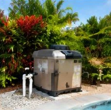 Heat pump pool heater hidden in a fenced side yard between a stucco wall and wooden fence
