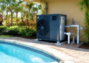 Heat pump pool heater hidden in a fenced side yard between a stucco wall and wooden fence