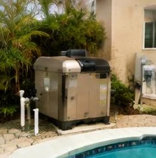 Pool heat pump installed beside a South Florida home — Pool Heater Maintenance in West Palm Beach