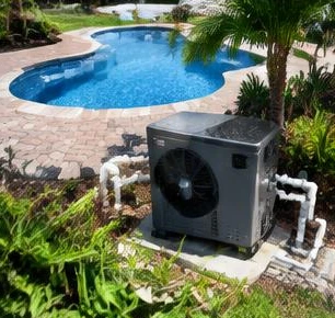 Heat pump pool heater hidden in a fenced side yard between a stucco wall and wooden fence