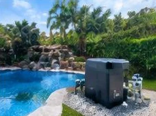 Heat pump pool heater hidden in a fenced side yard between a stucco wall and wooden fence