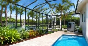 Heat pump pool heater hidden in a fenced side yard between a stucco wall and wooden fence