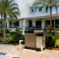 Heat pump pool heater hidden in a fenced side yard between a stucco wall and wooden fence