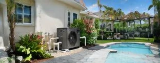 Pool heat pump installed beside a South Florida home — Pool Heaters in Loxahatchee
