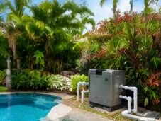 Heat pump pool heater hidden in a fenced side yard between a stucco wall and wooden fence