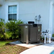Pool heat pump installed beside a South Florida home — Pool Heater Maintenance in North Palm Beach