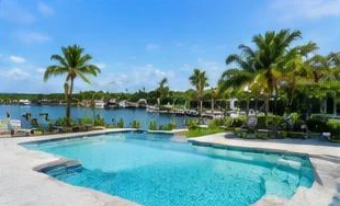 Pool heat pump installed beside a South Florida home — Pool Heater Repair in Ocean Ridge
