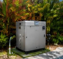 Heat pump pool heater hidden in a fenced side yard between a stucco wall and wooden fence