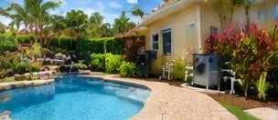 Heat pump pool heater hidden in a fenced side yard between a stucco wall and wooden fence