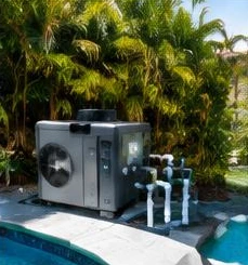 Heat pump pool heater hidden in a fenced side yard between a stucco wall and wooden fence