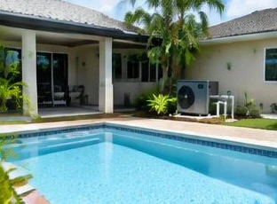 Pool heat pump installed beside a South Florida home — Pool Heater Maintenance in Loxahatchee