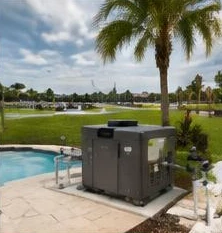 Heat pump pool heater hidden in a fenced side yard between a stucco wall and wooden fence