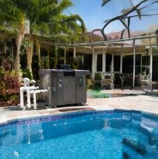 Heat pump pool heater hidden in a fenced side yard between a stucco wall and wooden fence