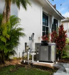 Heat pump pool heater hidden in a fenced side yard between a stucco wall and wooden fence