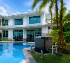 Pool heat pump installed beside a South Florida home — Pool Heater Repair in Boynton Beach