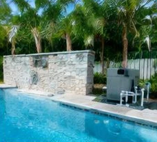 Heat pump pool heater hidden in a fenced side yard between a stucco wall and wooden fence