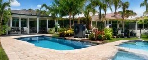 Heat pump pool heater hidden in a fenced side yard between a stucco wall and wooden fence