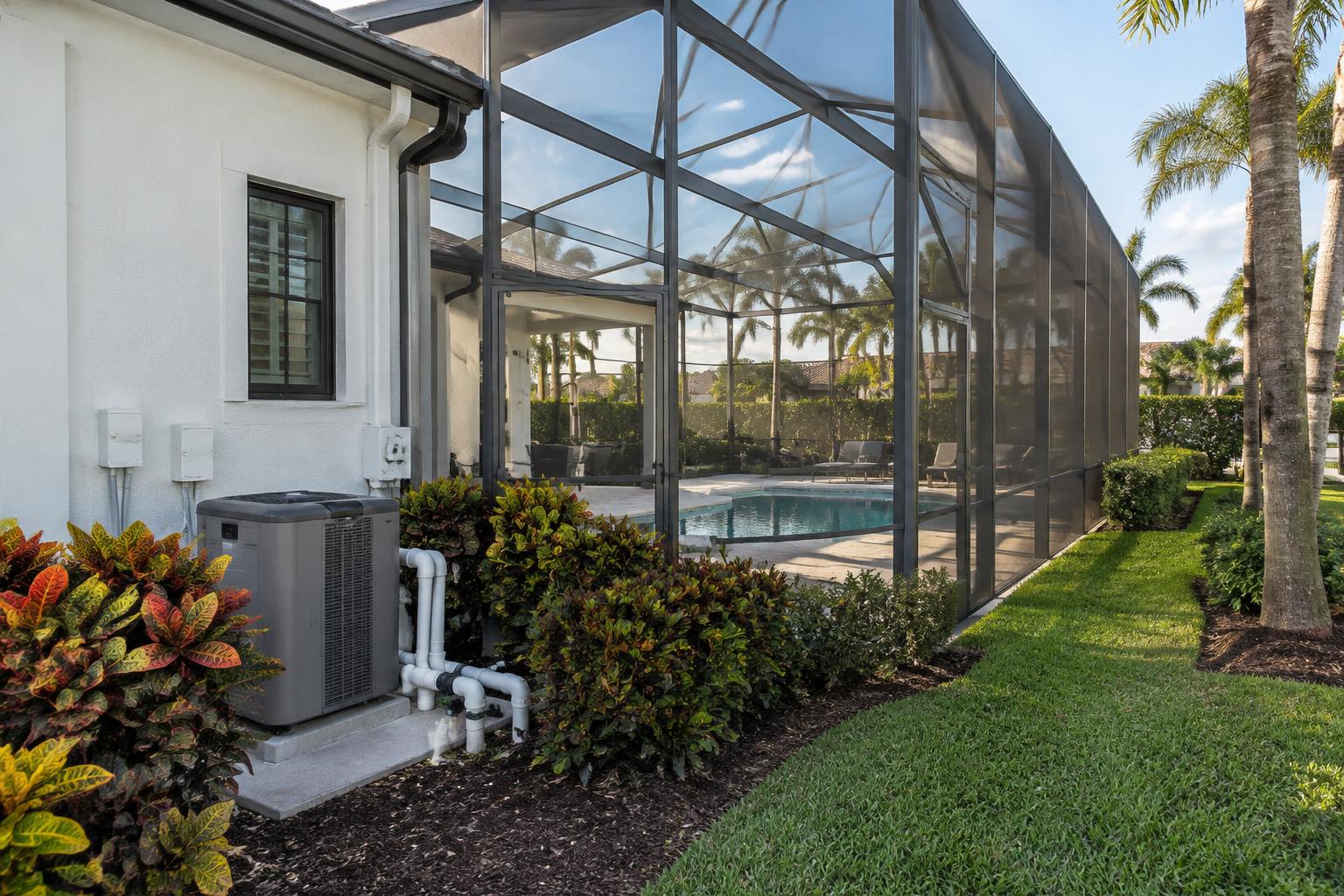 Pool heat pump beside a Jupiter screened pool enclosure at golden hour