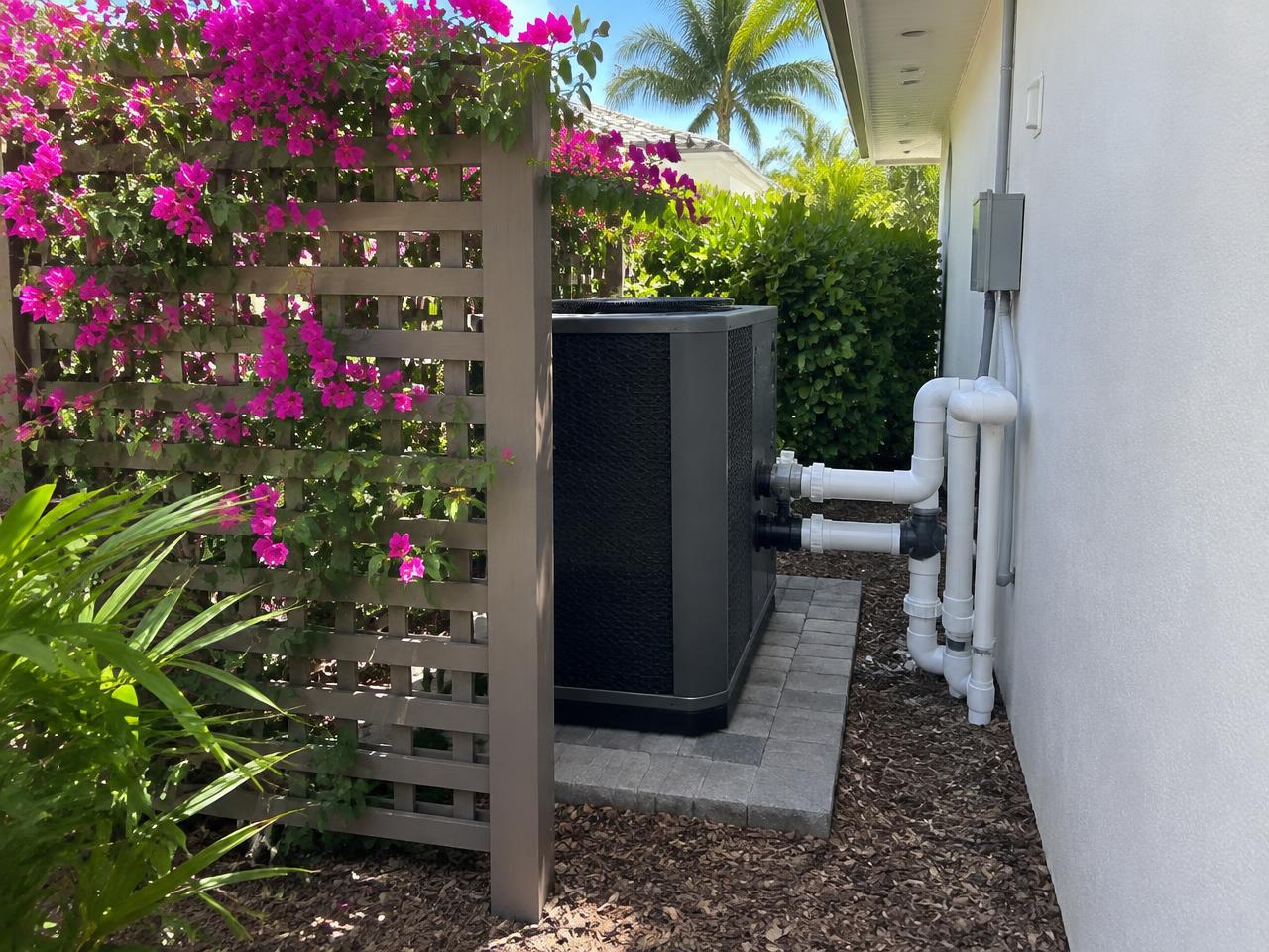 Pool heat pump hidden behind a cabana wall under a trellis